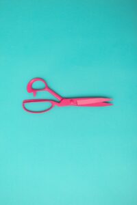 red handled scissors on blue surface